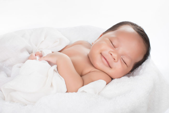 dieťa sa usmieva počas spánku